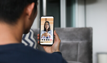 close up rear view of young man video streaming conference to consult about medical exam  and physical therapy with specialist and listen explaining about depress and illness at home for telemedicine