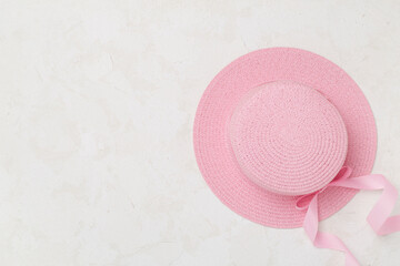 Pink hat on concrete background, top view. Summer concept