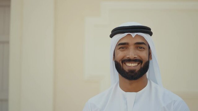 Handsome man with united arab emirates traditional kandura spending time outdoor in the city. Emirati young businessman from Dubai.