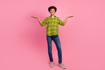Full size photo of nice young man hold empty space vs wear shirt isolated on pink color background