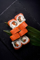 Philadelphia sushi roll with salmon and cream cheese on black board