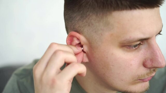 a man is cleaning his ears.
Ear hygiene.
A man holds a cotton swab in his hands.
Clean ears