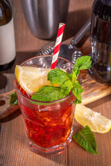 Cola and wine sweet sour alcoholic drink, Kalimotxo or calimocho boozy fizzy cocktail with ice cubes, lemon and mint, copy space