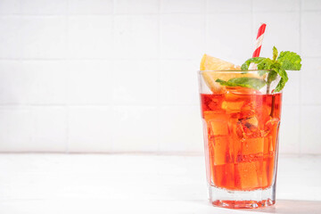 Cola and wine sweet sour alcoholic drink, Kalimotxo or calimocho boozy fizzy cocktail with ice cubes, lemon and mint, copy space