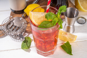 Cola and wine sweet sour alcoholic drink, Kalimotxo or calimocho boozy fizzy cocktail with ice cubes, lemon and mint, copy space