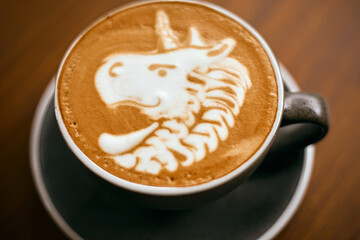 a cup of hot latte art coffee on wooden table