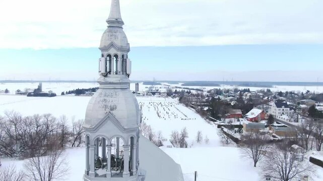 Drone crane shot rising in front of the church of St-Benoit de Mirabel, revealing the cemetery behind