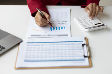 Businesswoman working with financial documents in the office is calculating income, expenses and planning a budget, Analyzing financial statistics in business reports.