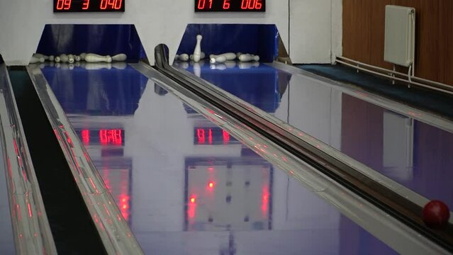 bowling game in the sports center. The bowling ball knocks down the skittles. Bowling ball on the lane to knock down the pins. 
