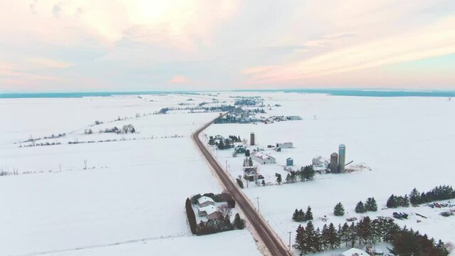 Drone shot at high altitude, flying backwards above a road near the village of St-Benoit de Mirabel
