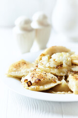 Dumplings with potato and cottage cheese stuffing (pierogi). Traditional Polish Christmas Dinner. Bright background.