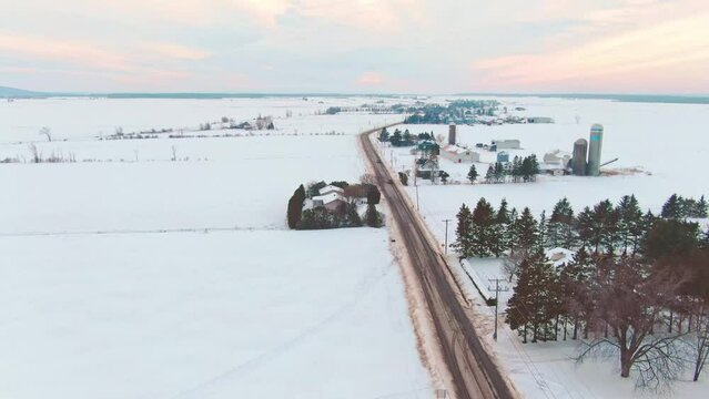 Drone shot at high altitude, descending above a road near the village of St-Benoit de Mirabel during a beautiful sunset