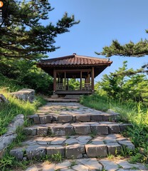 Obraz premium A stone path leads to a traditional Korean pavilion surrounded by lush greenery.