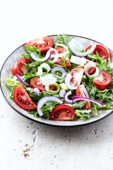 Salad with fresh tomatoes and arugula on a bright background. Close up.	