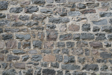 Old stone wall background texture close up. Texture of a stone wall. Old castle stone wall texture background. Stone wall as a background or texture. Part of a stone wall, for background.