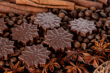 Food background. Coffee beans, cinnamon sticks, anise stars and chocolate candies top view.