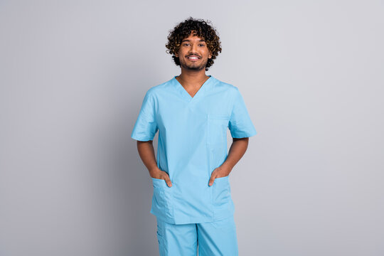 Photo of confident positive doctor man hold hands in uniform isolated pastel color background
