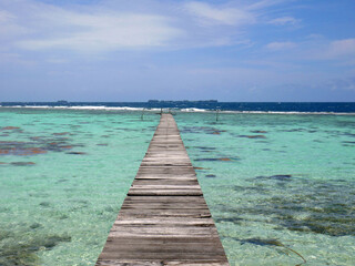 Fototapeta premium Wooden pier on beach with crystal clear turquoise waters