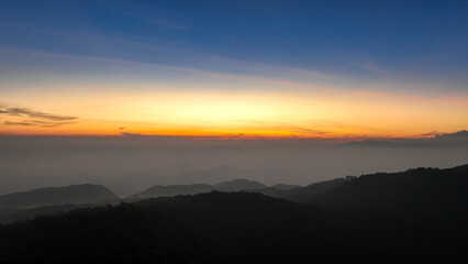 Aerial view of the sky above the hill of Mount Kencana, with beautiful clouds and mist covering the surroundings