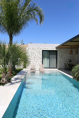 Tranquil image of an empty pool in the backyard of a country house on a beautiful sunny day. Close up, copy space, mountains on the background.
