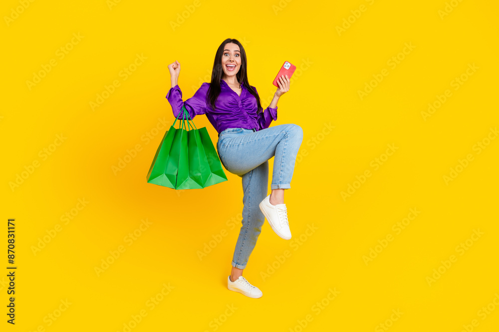 Canvas Prints Photo of positive smiling lady hold shopping bags cell phone raise fists up isolated bright color background