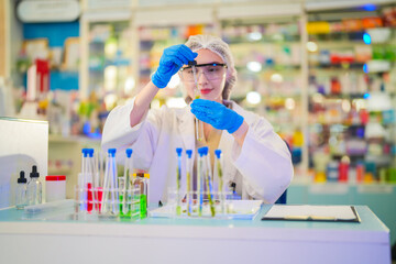 female scientist Experimenting through tubes of chemical liquids and plant samples. In a laboratory...