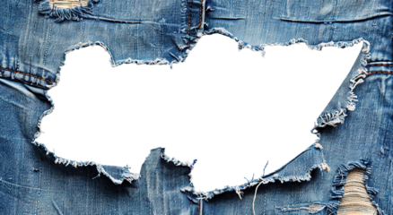 Large hole in worn blue denim fabric with frayed edges, cut out