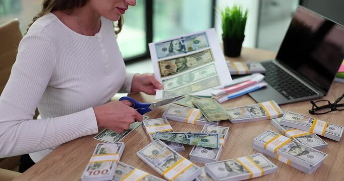 Woman trims excess paper from printed bills using scissors