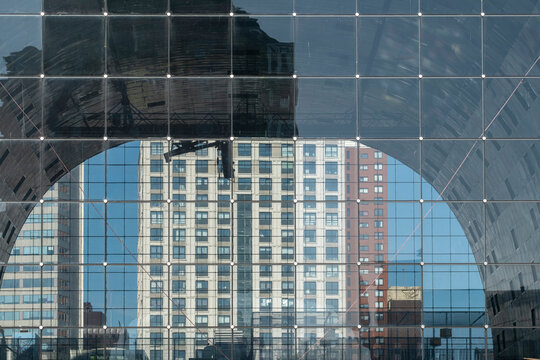 An artistic photograph capturing the reflection of various buildings on a glass facade, highlighting the interplay of architecture, urban landscape, and modern design elements in a city in Rotterdam
