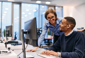 Digital Collaboration: Blonde Businesswoman and African American Partner Reviewing Documents Online