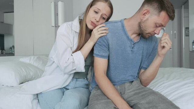 Unhappy, sad man in couple after argument with his woman looking down after conflict and quarrel. Girlfriend apologizes and make up her boyfriend. Upset couple try to reconcile after fight