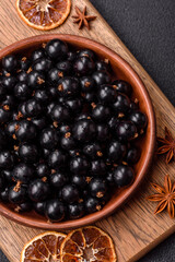 Ripe blackcurrant berries in droplets of water in a ceramic bowl