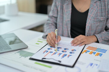 Business Professional Analyzing Financial Charts and Graphs in Modern Office Setting