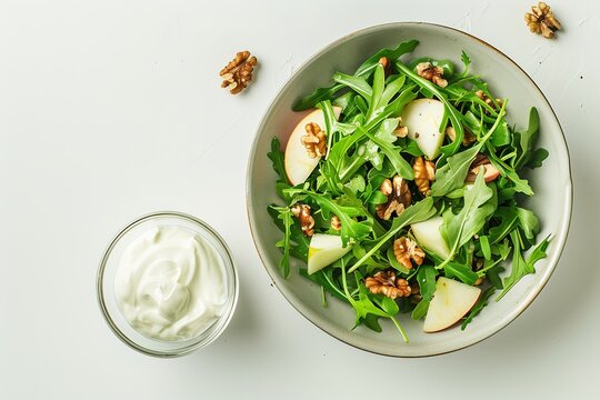 Minimalistic stock photo of an arugula salad with apple and walnuts in a bowl on a white table,