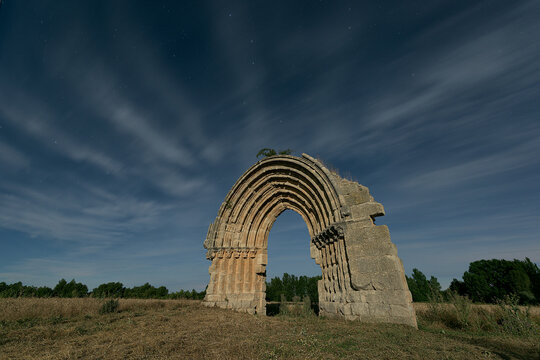 Night view of the arch of the missing church of San Miguel de Mazarreros, in Sasamon, Burgos, illuminated by the moonlight