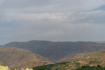 Fototapeta premium The sky is cloudy and the mountains are covered in trees