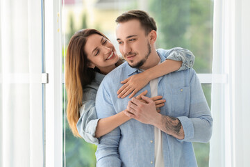 Happy woman hugging her boyfriend at home