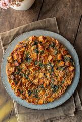 Potato and spinach tortilla on the table. Potato frittata.