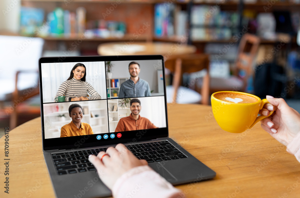 Poster a person sits in a cafe, using a laptop to video conference with three colleagues. they are smiling 