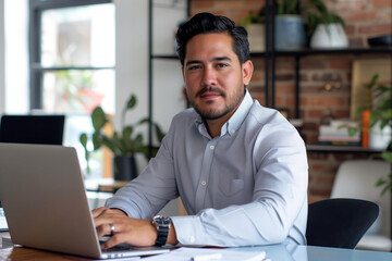 Hispanic entrepreneur, manager or businessman work on his laptop in his office, embodies professionalism and productivity, ideal for conveying success and leadership in multicultural business concept.