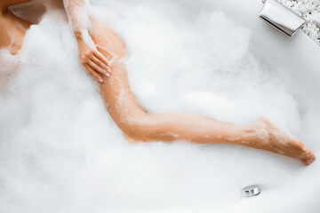 Fototapeta premium Woman Body In Bath Foam, Top view. Enjoying And Relaxing In Spa Hotel