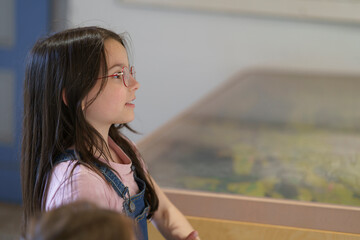 Little cute teenage girl with glasses in the museum. Children's education concept