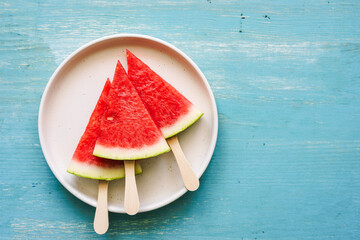 Frische Wassermelonen Stücke auf einem Teller. Türkiser Holztisch, Sommer.