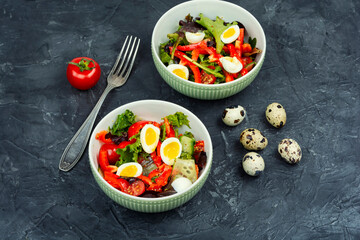 Salad with quail egg, tomato and lettuce.