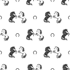 Seamless pattern with black and white horses and horseshoes on a white background
