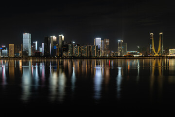 Fototapeta premium Modern city skyline and urban buildings at night in Hangzhou, China, featuring skyscrapers, city lights, nightlife, a vibrant skyline, and a blend of futuristic design landmarks in the Hangzhou CBD