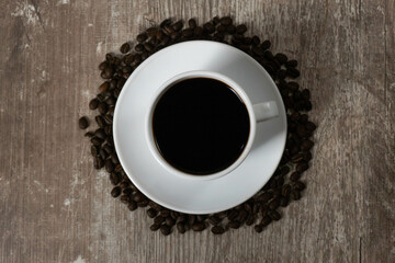 white coffee cup and coffee beans on wooden background