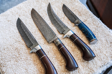 traditional oriental Uzbek chust knives made of Damascus steel with wooden handles in a workshop in...