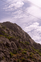 A mountain with a cloudy sky in the background