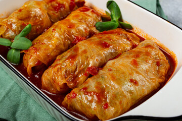 Stuffed cabbage rolls with minced meat, in tomato sauce, top view, without people, in the spotlight.